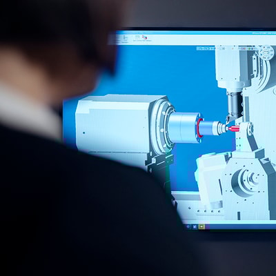 A woman looking in at a computer screen showing a digital version of a turning operations
