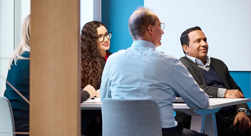 Four persons in a meeting room 