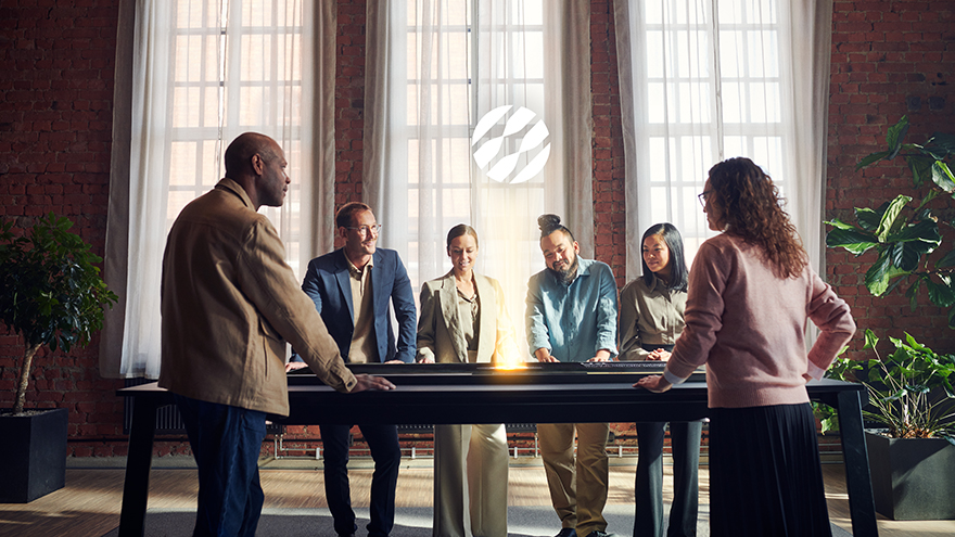 Three men and three women standing around a table in a room with big windows. The Sandvik logotype is levitating above their heads.